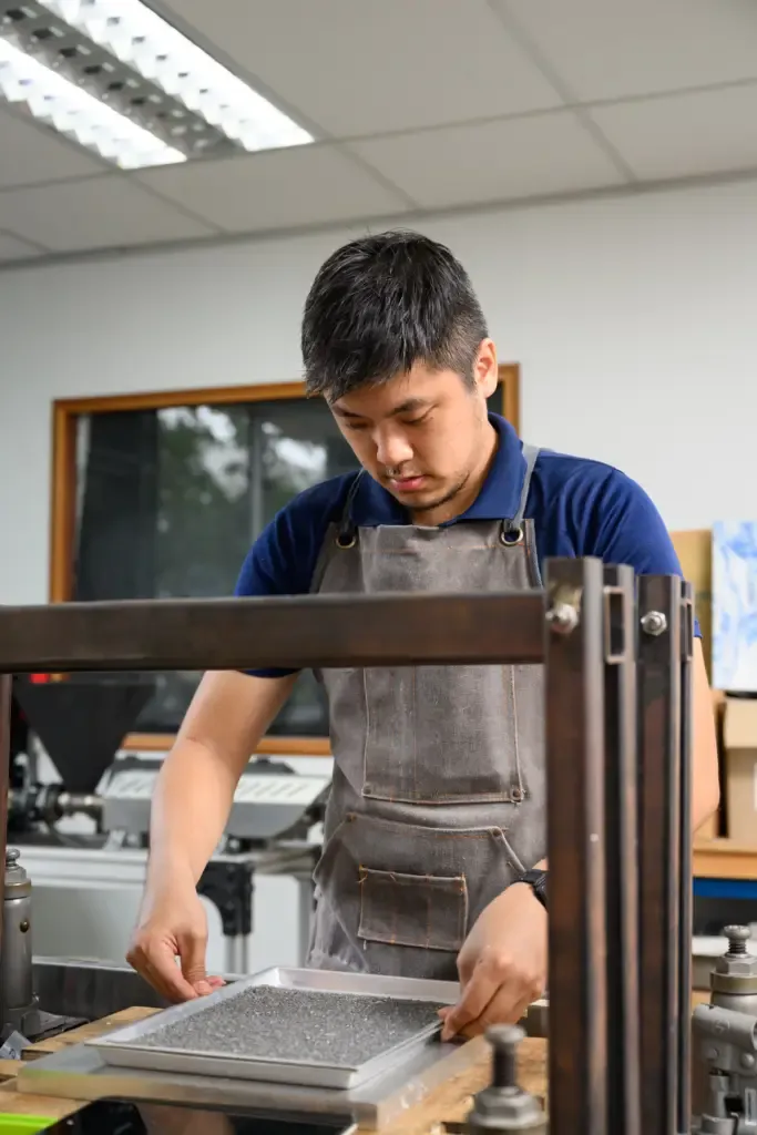 Carefully removing a freshly moulded recycled plastic part from a custom-engineered Semula Asia mould.