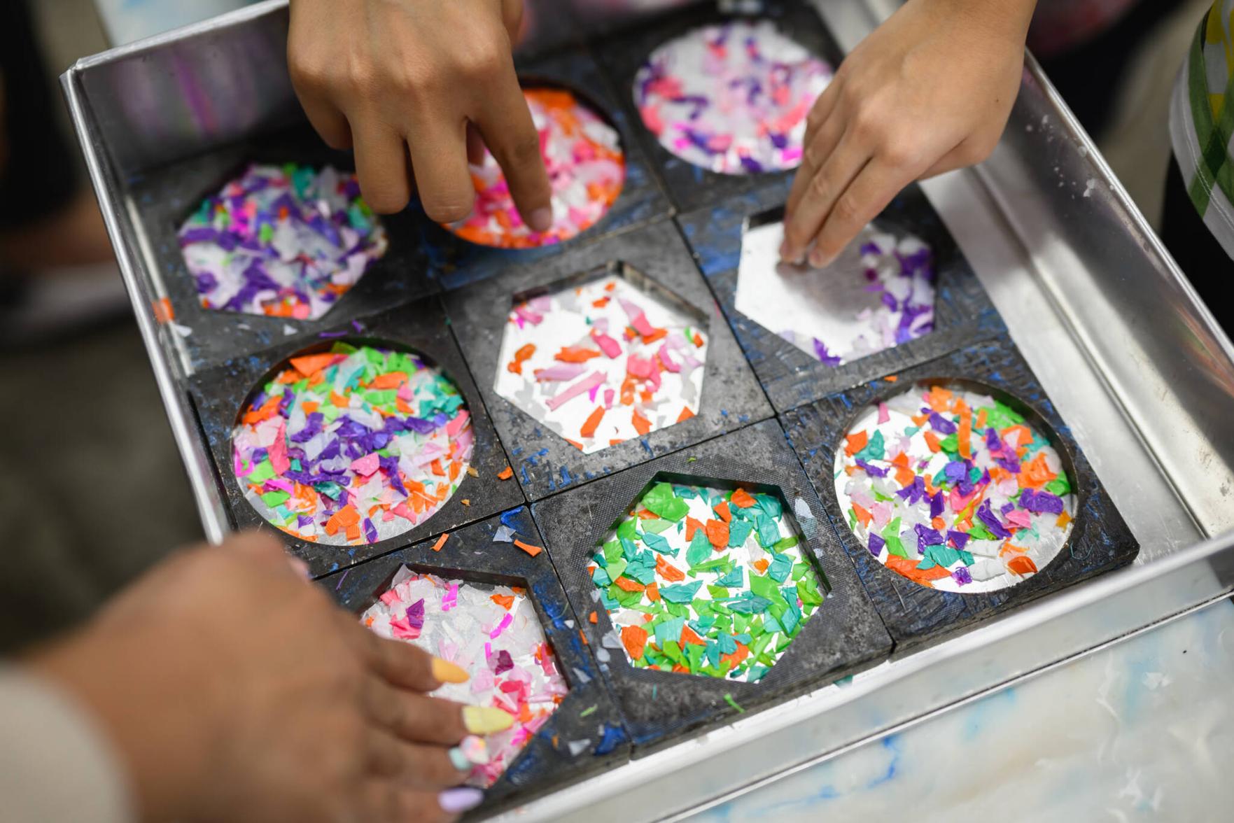 Semula Asia expert guiding a student through the creative process of upcycling plastic waste into art.