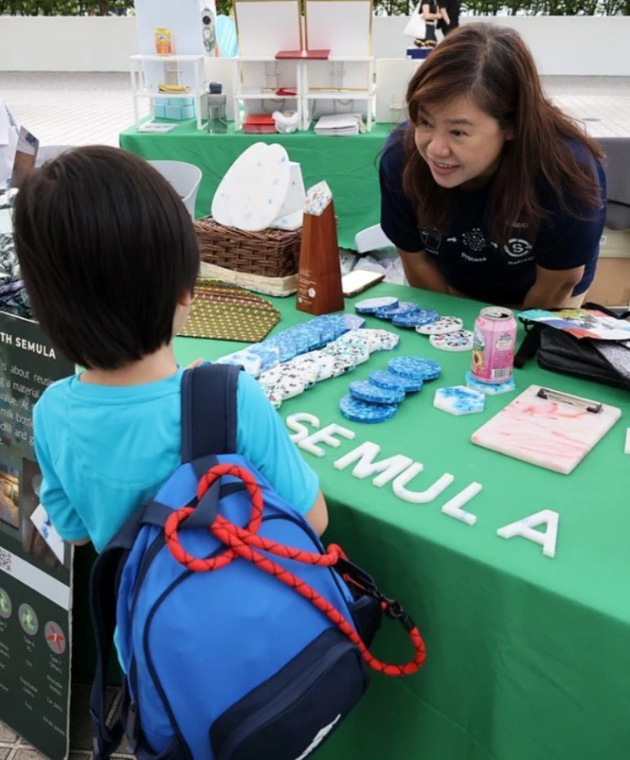 Participants gathered around at a Semula Asia workshop, learning the science of plastic upcycling.